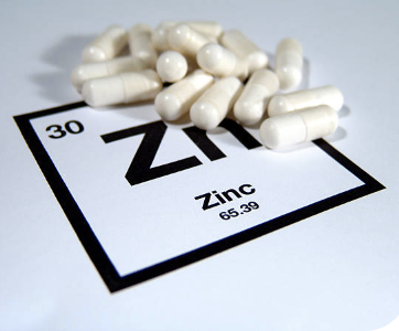 Zirconium pills utilized in physical therapy atop a periodic table.