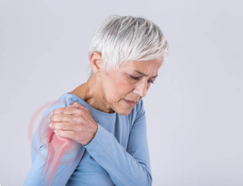 An older woman seeking physical therapy for shoulder pain.