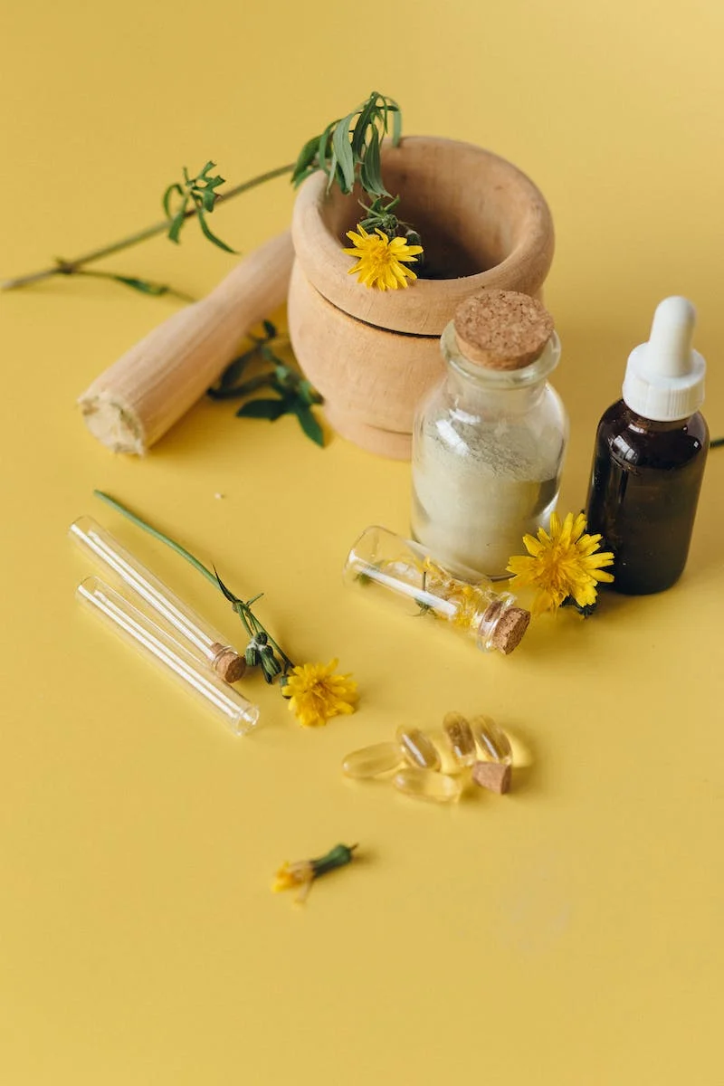 A yellow background with yellow flowers, herbs and a mortar and pestle representing a fusion of physical therapy and herbal remedies.