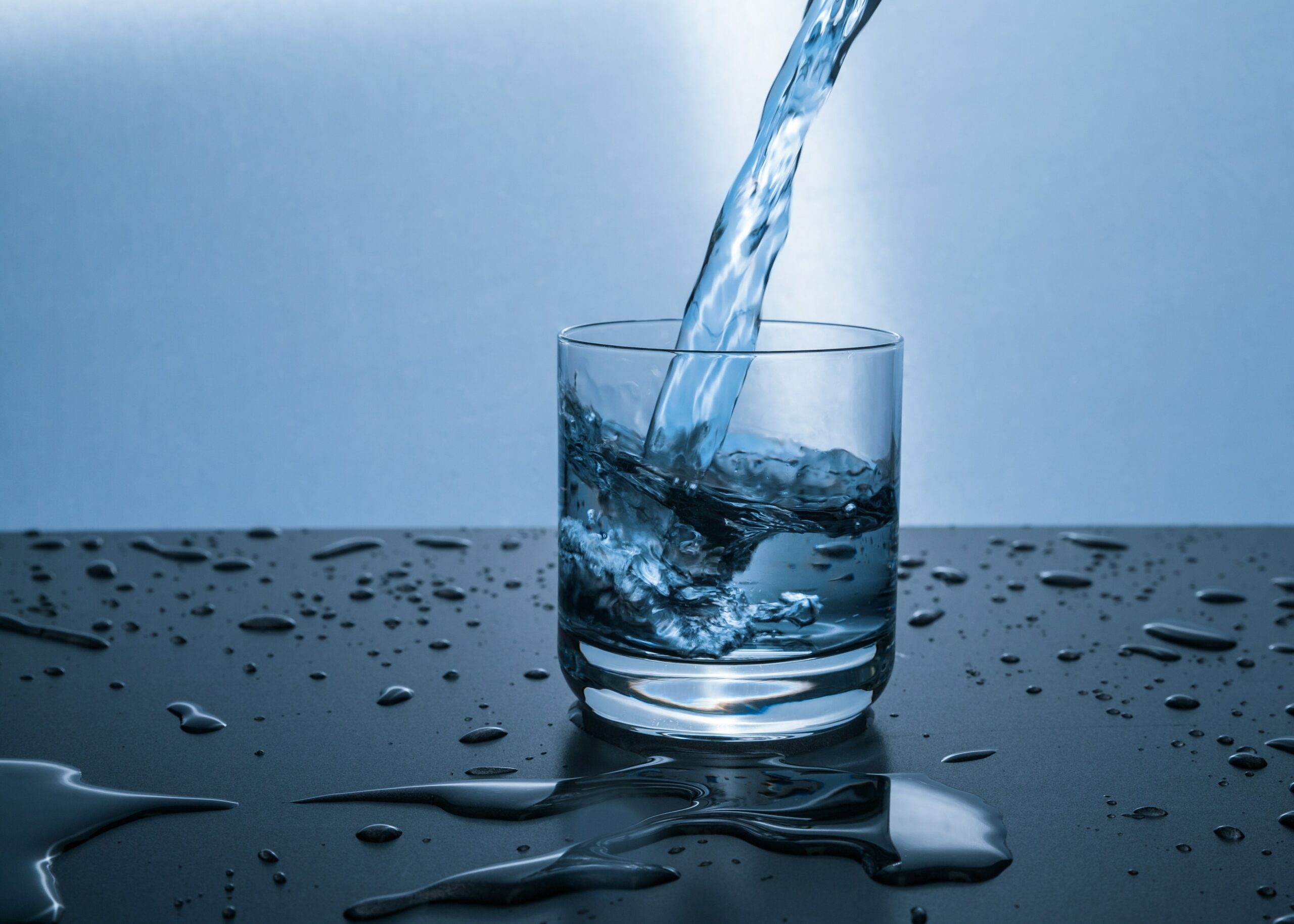 Water is being poured into a glass of water for physical therapy.