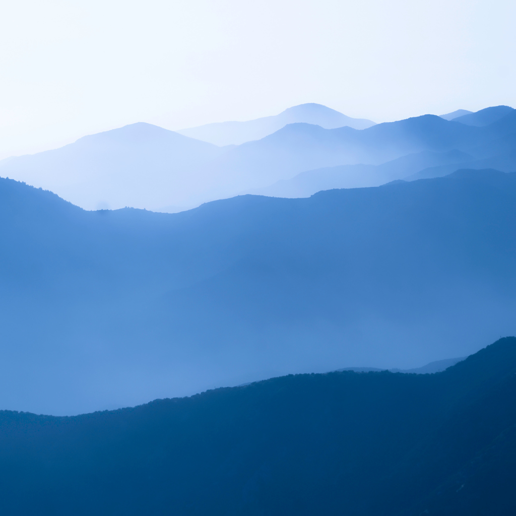 A scenic view of mountains under a blue sky.