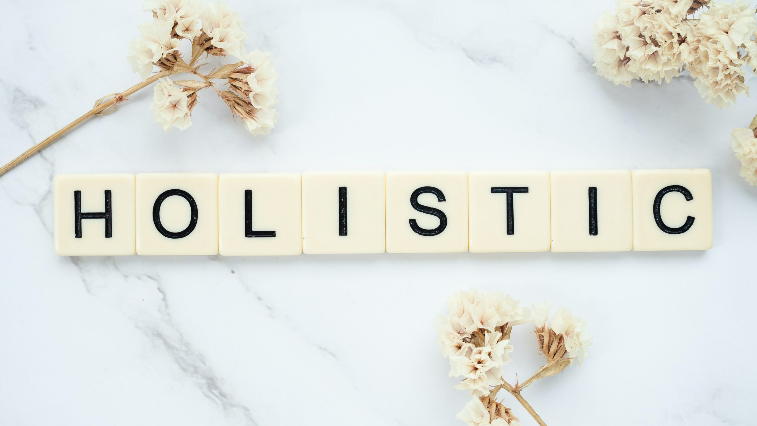 The word holistic spelled out on a marble table, representing the holistic approach in physical therapy.