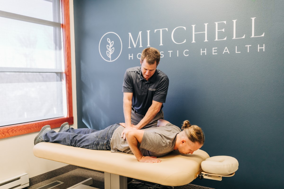 A man is getting physical therapy at Mitchell Holistic Health.