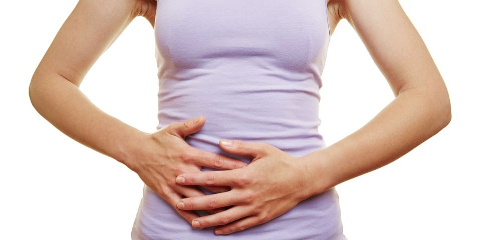 A woman receiving physical therapy with her hands on her stomach.